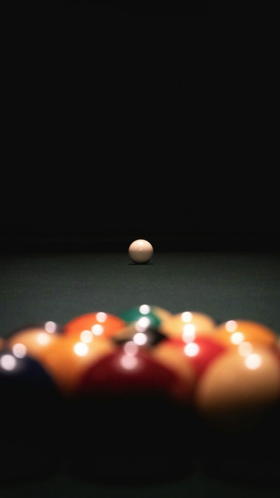 Billiard balls arranged on a green pool table ready for competition
