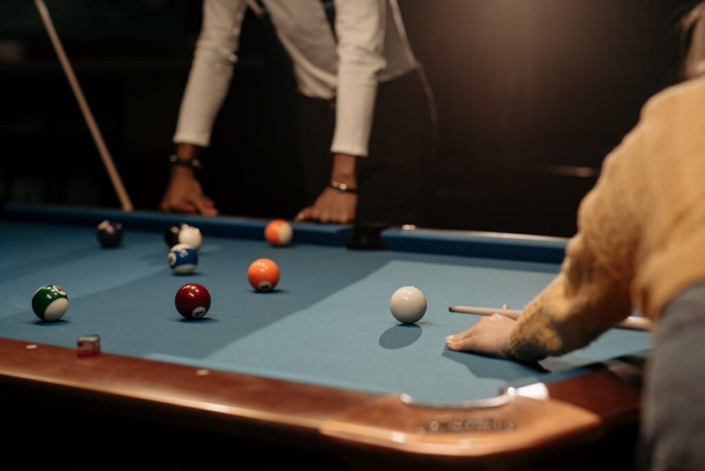 Two competitive billiards players during a match in a pool hall, representing international tournament preparation