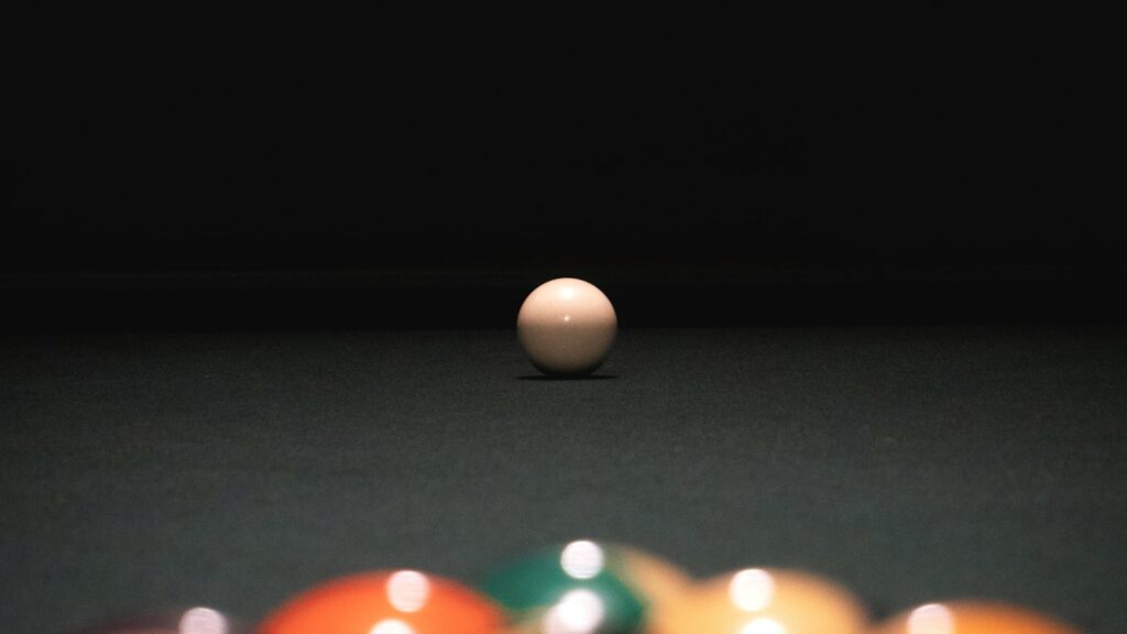 Cue ball facing a rack of pool balls, illustrating 8-ball pattern play and run-out sequencing